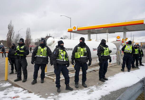 February 13, 2022, WINDSOR, ON, CANADA: Police officers guard a gas station and propane tank as they remove truckers and supporters after a court injunction gave police the power to enforce the law after blocking the access leading from the Ambassador Bridge, linking Detroit and Windsor, as truckers and their supporters continue to protest against the COVID-19 vaccine mandates and restrictions in Windsor, Ont., on Sunday, February 13, 2022. WINDSOR CANADA  - ZUMAc35_ 20220213_zaf_c35_067 Copyright: xNathanxDenettex