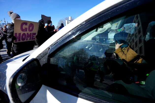 February 13, 2022, Ottawa, ON, CAN: A protester puts their head in their hand as they sit blocked in by local residents during a counter protest to stop vehicles driving in a convoy from making their way along Riverside Drive en route to Parliament Hill, on the 17th day of a protest against COVID-19 measures that has grown into a broader anti-government protest, in Ottawa, on Sunday, Feb. 13, 2022. Ottawa CAN  - ZUMAc35_ 20220213_zaf_c35_075 Copyright: xJustinxTangx