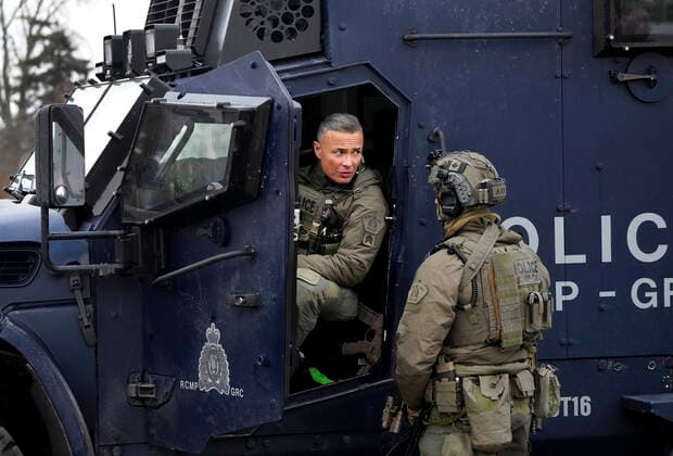 February 13, 2022, WINDSOR, ON, CANADA: Two RCMP tactical unit officers monitor the situation as police remove truckers and supporters after a court injunction gave police the power to enforce the law after protesters blocked the access leading from the Ambassador Bridge, linking Detroit and Windsor, as truckers and their supporters continue to protest against COVID-19 vaccine mandates and restrictions, in Windsor, Ont., Sunday, Feb. 13, 2022. WINDSOR CANADA  - ZUMAc35_ 20220213_zaf_c35_047 Copyright: xNathanxDenettex