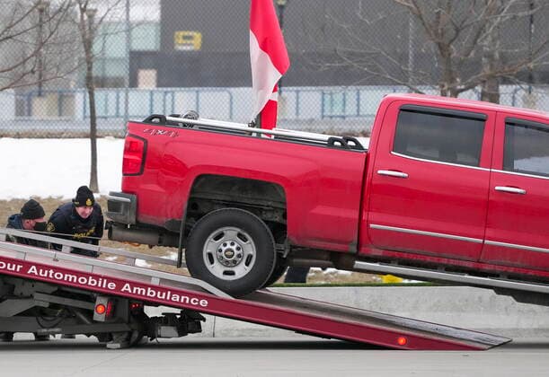February 13, 2022, WINDSOR, ON, CANADA: Police tow a truck as they remove all truckers and supporters after a court injunction gave police the power to enforce the law after protesters blocked the access leading from the Ambassador Bridge, linking Detroit and Windsor, as truckers and their supporters continue to protest against COVID-19 vaccine mandates and restrictions, in Windsor, Ont., Sunday, Feb. 13, 2022. WINDSOR CANADA  - ZUMAc35_ 20220213_zaf_c35_042 Copyright: xNathanxDenettex