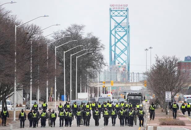 February 13, 2022, WINDSOR, ON, CANADA: Police walk the line to remove all truckers and supporters after a court injunction gave police the power to enforce the law after protesters blocked the access leading from the Ambassador Bridge, linking Detroit and Windsor, as truckers and their supporters continue to protest against COVID-19 vaccine mandates and restrictions, in Windsor, Ont., Sunday, Feb. 13, 2022. WINDSOR CANADA  - ZUMAc35_ 20220213_zaf_c35_034 Copyright: xNathanxDenettex