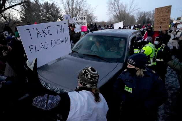February 13, 2022, Ottawa, ON, CAN: A resident holds a sign calling for a convoy participant to remove their Canadian flag as they negotiate to release vehicles from a counter protest that blocked Riverside Drive for hours, in Ottawa, Sunday, Feb. 13, 2022. The protest, which began as a cross country convoy against COVID-19 measures but has manifested into a broader anti-government protest, has been marked by the sound of truck horns and the waving of the Canadian flag, sometimes upside down, which residents argued was a co-opting of the flag. Ottawa CAN  - ZUMAc35_ 20220213_zaf_c35_118 Copyright: xJustinxTangx