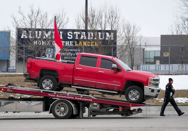 February 13, 2022, Windsor, Ontario, Canada: Police tow a truck as they remove all truckers and supporters after a court injunction gave police the power to enforce the law after protesters blocked the access leading from the Ambassador Bridge, linking Detroit and Windsor, as truckers and their supporters continue to protest against COVID-19 vaccine mandates and restrictions. Windsor Canada  - ZUMAc35_ 20220213_zaf_c35_044 Copyright: xNathanxDenettex