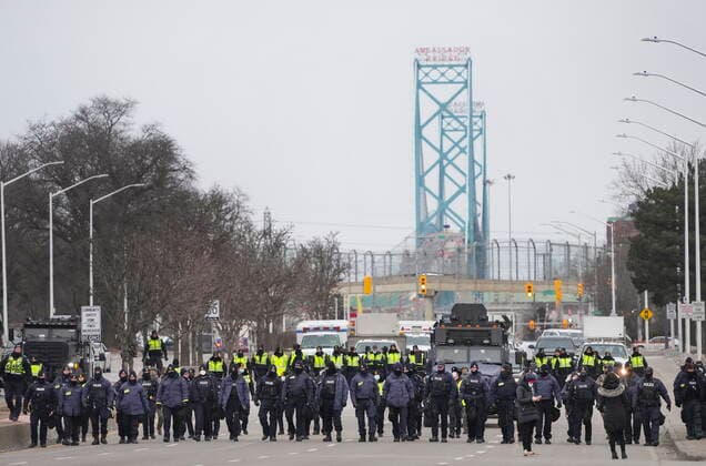 February 13, 2022, Windsor, Ontario, Canada: Police walk the line to remove all truckers and supporters after a court injunction gave police the power to enforce the law after protesters blocked the access leading from the Ambassador Bridge, linking Detroit and Windsor, as truckers and their supporters continue to protest against COVID-19 vaccine mandates and restrictions, in Windsor, Ont., Sunday, Feb. 13, 2022. Windsor Canada  - ZUMAc35_ 20220213_zaf_c35_037 Copyright: xNathanxDenettex