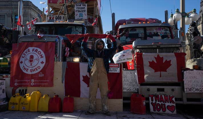February 14, 2022, Ottawa, ON, Canada: A protester holds a hockey stick wrapped in a Canadian flag above his head, Monday, Feb. 14, 2022 in Ottawa. The protesters are decrying federal vaccine mandates and provincial COVID-19 restrictions aimed at slowing the spread of the virus, some of which are being rolled back by provinces. Ottawa Canada  - ZUMAc35_ 20220214_zaf_c35_118 Copyright: xAdrianxWyldx
