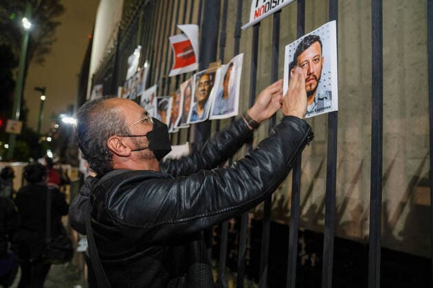 February 14, 2022, Mexico City, Mexico: A man hangs pictures of the five journalists who have been murdered in Mexico in 2022. Dozens of journalists came together to protest outside the offices of the Ministry of Interior in Mexico City. It was part of a simultaneous national protest that took place across Mexico following the murder of the fifth journalist in 2022. Mexico City Mexico - ZUMAs197 20220214_zaa_s197_405 Copyright: xLexiexHarrison-Crippsx