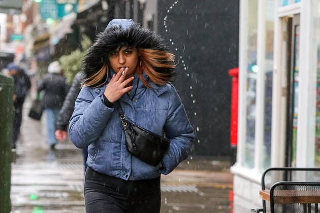February 15, 2022, London, United Kingdom: A woman walks as she smokes a cigarette on the streets of London. London United Kingdom - ZUMAs197 20220215_zaa_s197_206 Copyright: xDinendraxHariax