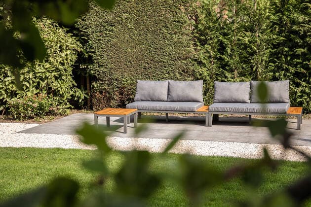 Comfortable gray sofa placed near lush green trees on terrace with grassy lawn on sunny summer day in house garden, Property released CasaMedia_RichardWagnerstraat1_32.jpg Copyright: xCasaxMediax Model Released