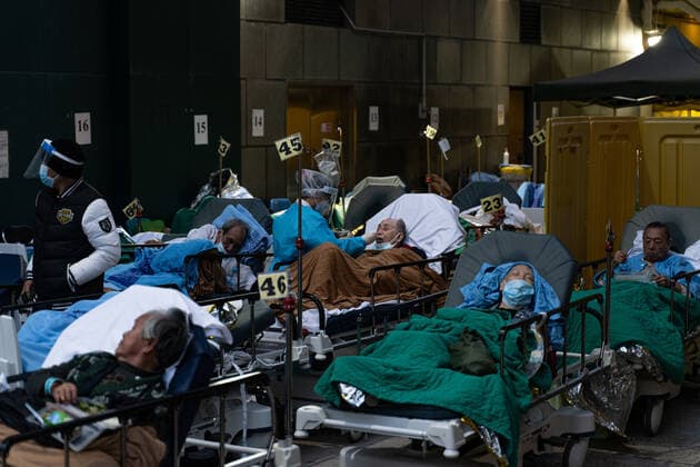 Hong Kong s COVID-19 Infections Soar On February 16, 2022, a patient lies in a hospital bed waiting for medical treatment in a temporary holding area outside Caritas Medical Center in Hong Kong, China, while medical staff feed the patient. The Food and Health Bureau confirmed a new record of 4,285 infections, while 7,000 people initially tested positive, a near-record high. At least 12,000 infected people are waiting to be admitted to hospitals as COVID-19 cases overwhelm the public health system. Hong Kong China  Copyright: xLeungxManxHeix originalFilename: manhei-notitle220216_npYEV.jpg