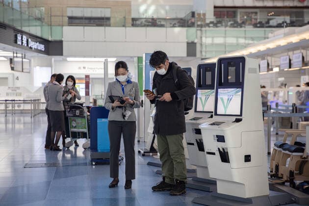 February 17, 2022, Tokyo, Japan: All Nippon Airways (ANA) employee helps a passenger with his ticket near the check-in counter inside the International Terminal at Haneda Airport..Japan™s Prime Minister Fumio Kishida announced at his press.Conference on February 17th 2022 that Japan will ease entry.Restrictions for foreign students and business travelers as well as.shorten the quarantine period for all arrivals to three days. Tokyo Japan - ZUMAs197 20220217_zaa_s197_109 Copyright: xStanislavxKogikux