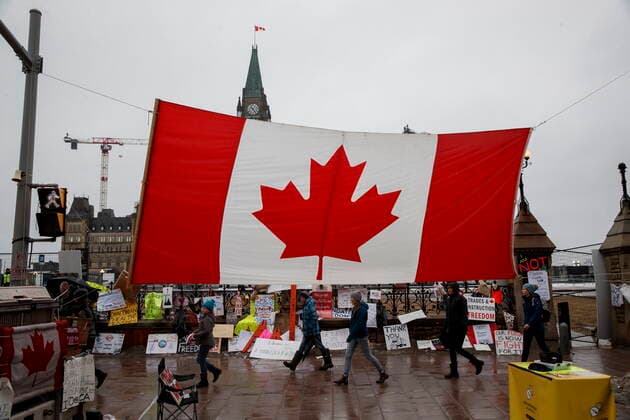 February 17, 2022, OTTAWA, ON, CANADA: Protestors and supporters walk in front of Parliament Hill in downtown Ottawa, Canada, as a protest against COVID-19 measures that has grown into a broader anti-government protest continues to occupy downtown Ottawa on Thursday, Feb. 17, 2022. OTTAWA CANADA  - ZUMAc35_ 20220217_zaf_c35_037 Copyright: xColexBurstonx