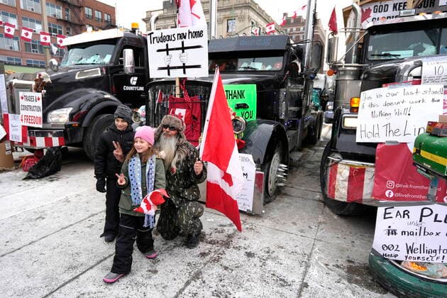February 16, 2022, Ottawa, ON, CAN: Children pose with a protester in front of semi-trailer trucks on Wellington Street, on the 20th day of a protest against COVID-19 measures that has grown into a broader anti-government protest, in Ottawa, on Wednesday, Feb. 16, 2022. Ottawa CAN  - ZUMAc35_ 20220216_zaf_c35_031 Copyright: xJustinxTangx