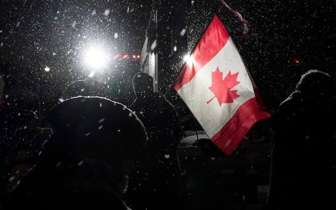 News Bilder des Tages February 17, 2022, Ottawa, ON, Canada: A protester waves a Canadian flag as snow falls as other protesters move about as a demonstration against COVID-19 measures, that has grown into a broader anti-government protest, continues to occupy downtown Ottawa, Thursday, Feb. 17, 2022. Ottawa Canada  - ZUMAc35_ 20220217_zaf_c35_171 Copyright: xAdrianxWyldx