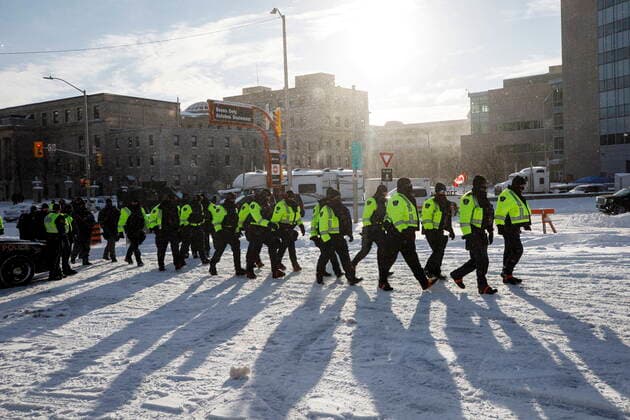Kanada, Protest gegen Corona-Maßnahmen in Ottawa - Polizei beginnt mit Räumung von LKW-Blockade February 18, 2022, OTTAWA, ON, CANADA: Police officers walk around vehicles parked in downtown Ottawa, after taking protesters into custody, Friday, Feb. 18, 2022. OTTAWA CANADA  - ZUMAc35_ 20220218_zaf_c35_077 Copyright: xColexBurstonx