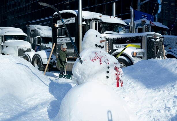 Kanada, Protest gegen Corona-Maßnahmen in Ottawa - Polizei beginnt mit Räumung von LKW-Blockade February 18, 2022, Ottawa, ON, Canada: A woman shovels snow from around a truck taking part in protests following an overnight storm, Friday, Feb. 18, 2022 in Ottawa. Ottawa Canada  - ZUMAc35_ 20220218_zaf_c35_084 Copyright: xAdrianxWyldx