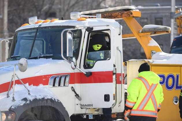 Kanada, Protest gegen Corona-Maßnahmen in Ottawa - Polizei beginnt mit Räumung von LKW-Blockade February 18, 2022, Ottawa, ON, CAN: A tow operator wears a balaclava to cover their identity as he prepares to remove a truck from a blockade on Nicholas St. in Ottawa, on Friday, Feb. 18, 2022. Ottawa CAN  - ZUMAc35_ 20220218_zaf_c35_089 Copyright: xJustinxTangx