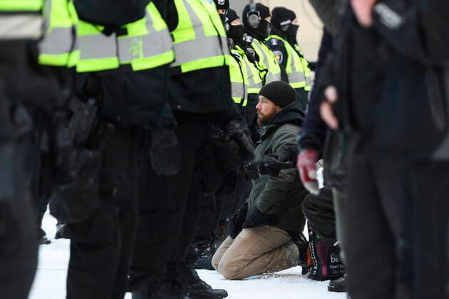 Kanada, Protest gegen Corona-Maßnahmen in Ottawa - Polizei beginnt mit Räumung von LKW-Blockade February 18, 2022, Ottawa, ON, CAN: A protester kneels in front of police officers on Rideau Street as they work to break up the truck blockade in Ottawa, on Friday, Feb. 18, 2022. Ottawa CAN  - ZUMAc35_ 20220218_zaf_c35_096 Copyright: xJustinxTangx