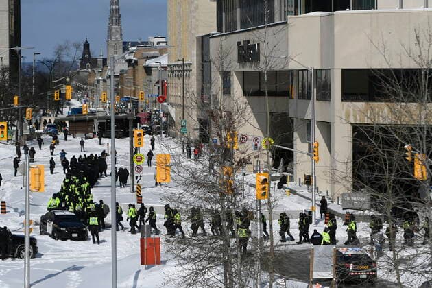 Kanada, Protest gegen Corona-Maßnahmen in Ottawa - Polizei beginnt mit Räumung von LKW-Blockade February 18, 2022, Ottawa, ON, CAN: A lineup of police officers assemble on Colonel By Drive near the truck blockade in Ottawa, on Friday, Feb. 18, 2022. Ottawa CAN  - ZUMAc35_ 20220218_zaf_c35_095 Copyright: xJustinxTangx