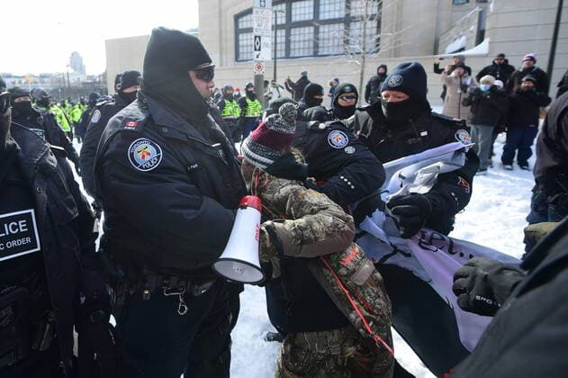 Kanada, Protest gegen Corona-Maßnahmen in Ottawa - Polizei beginnt mit Räumung von LKW-Blockade February 18, 2022, Ottawa, ON, CAN: A protester is taken into custody by police officers on Colonel By Drive near the truck blockade in Ottawa, on Friday, Feb. 18, 2022. Ottawa CAN  - ZUMAc35_ 20220218_zaf_c35_109 Copyright: xJustinxTangx