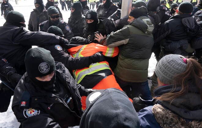 Kanada, Protest gegen Corona-Maßnahmen in Ottawa - Polizei beginnt mit Räumung von LKW-Blockade February 18, 2022, Ottawa, ON, Canada: Police pull a man behind their lines as they work to end a protest, which started in opposition to mandatory COVID-19 vaccine mandates and grew into a broader anti-government demonstration and occupation, in Ottawa, Friday, Feb. 18, 2022. Ottawa Canada  - ZUMAc35_ 20220218_zaf_c35_130 Copyright: xAdrianxWyldx