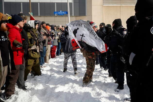 Kanada, Protest gegen Corona-Maßnahmen in Ottawa - Polizei beginnt mit Räumung von LKW-Blockade February 18, 2022, OTTAWA, ON, CANADA: A protester confronts a line of police officers, as authorities move to end a protest against COVID-19 measures that has grown into a broader anti-government protest and occupation, in Ottawa, Friday, Feb. 18, 2022. OTTAWA CANADA  - ZUMAc35_ 20220218_zaf_c35_138 Copyright: xColexBurstonx