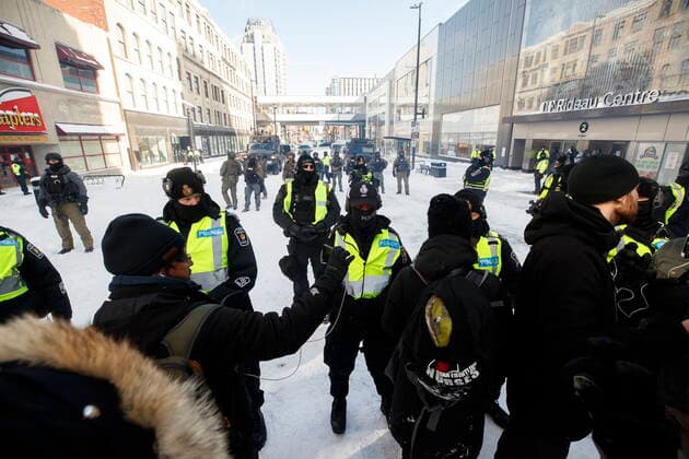 Kanada, Protest gegen Corona-Maßnahmen in Ottawa - Polizei beginnt mit Räumung von LKW-Blockade February 18, 2022, OTTAWA, ON, CANADA: Protestors and police officers interact, as authorities move to end a protest against COVID-19 measures that has grown into a broader anti-government protest and occupation, in Ottawa, Friday, Feb. 18, 2022. OTTAWA CANADA  - ZUMAc35_ 20220218_zaf_c35_140 Copyright: xColexBurstonx