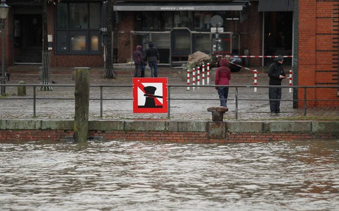 Passanten stehen während des Orkantiefs Zeynep auf dem Hamburger Fischmarkt. Zeynep sorgte in Hamburg für eine schwere Sturmflut. Der Wasserstand am Pegel St. Pauli erreichte am Samstagmorgen gegen 5.30 Uhr 3,75 Meter über dem mittleren Hochwasser. Altona Hamburg *** Passers-by stand in the Hamburg fish market during hurricane Zeynep Zeynep caused a severe storm surge in Hamburg The water level at the St Pauli gauge reached 3.75 meters above mean high water Altona Hamburg at around 5 30 on Saturday morning