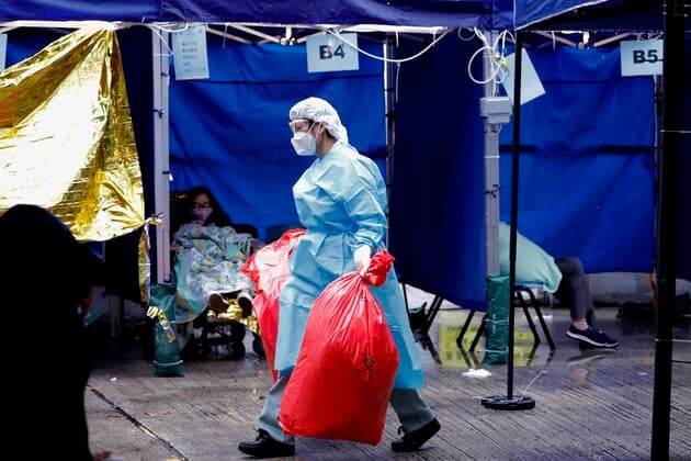 February 19, 2022, HONG KONG, CHINA: A medical staff move bags of clinical wastes outside Caritas Medical Centre where tents are set up for patients awaiting to receive medical care under cold wet weather.Feb-19,2022Hong Kong.ZUMA HONG KONG CHINA - ZUMAl137 20220219_zap_l137_008 Copyright: xLiauxChung-renx