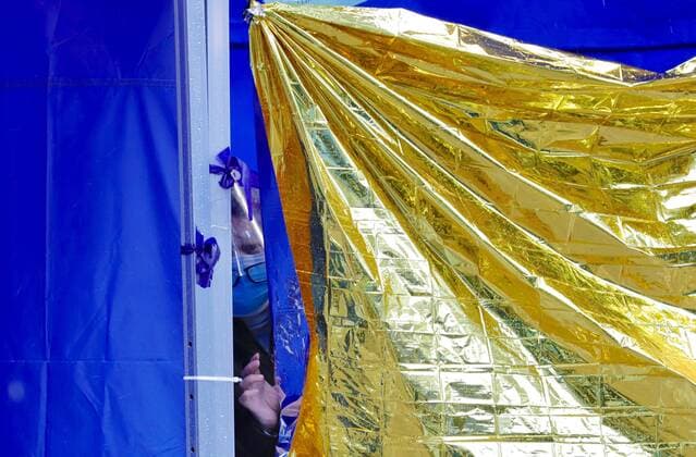 February 19, 2022, HONG KONG, CHINA: A female patient peeping through a curtain of thermal shield under a makeshift tents being set up outside Caritas Medical Centre to facilitate waiting patients for medical care.Feb-19,2022Hong Kong.ZUMA HONG KONG CHINA - ZUMAl137 20220219_zap_l137_010 Copyright: xLiauxChung-renx