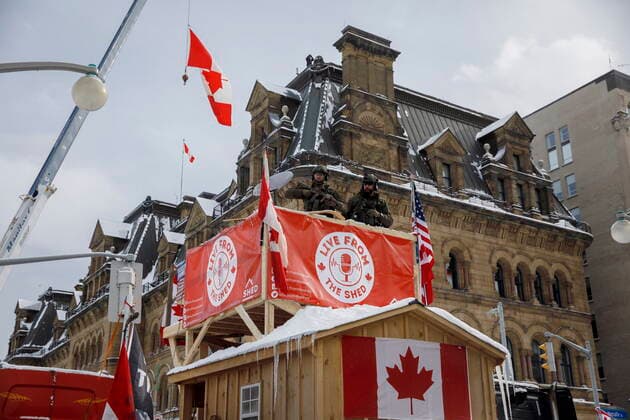 February 19, 2022, Ottawa, ON, Canada: Police watch as officers move in to clear downtown Ottawa near Parliament hill of protesters after weeks of demonstrations on Saturday, Feb. 19, 2022. Police arrested scores of demonstrators and towed away vehicles Friday in Canada s besieged capital, and a stream of trucks started leaving under the pressure, raising authorities hopes for an end to the three-week protest against the country s COVID-19 restrictions. Ottawa Canada  - ZUMAc35_ 20220219_zaf_c35_075 Copyright: xColexBurstonx