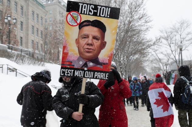 February 19, 2022, QUEBEC, PQ, Canada: A man carries a sign that pictures Premier Francois Legault as a North Korean leader as hundreds of people demonstrate against COVID-19 measures in front of the legislature in Quebec City, Saturday, Feb. 19, 2022. QUEBEC Canada  - ZUMAc35_ 20220219_zaf_c35_094 Copyright: xJacquesxBoissinotx