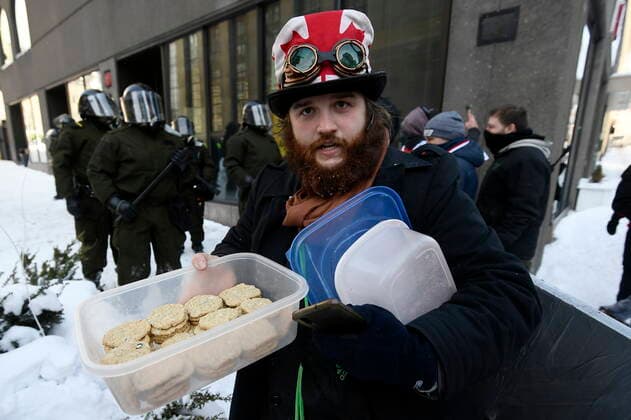 February 19, 2022, Ottawa, ON, CANADA: A protester offers cookies as police take action to put an end to a protest, which started in opposition to mandatory COVID-19 vaccine mandates and grew into a broader anti-government demonstration and occupation, in Ottawa, Saturday, Feb. 19, 2022. Ottawa CANADA  - ZUMAc35_ 20220219_zaf_c35_106 Copyright: xJustinxTangx