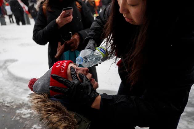 February 19, 2022, OTTAWA, ON, CANADA: A woman is helped after being pepper sprayed by police as they push back protestors as authorities work to end a protest against COVID-19 measures that had grown into a broader anti-government demonstration and occupation lasting for weeks, in Ottawa, Saturday, Feb. 19, 2022. OTTAWA CANADA  - ZUMAc35_ 20220219_zaf_c35_112 Copyright: xColexBurstonx