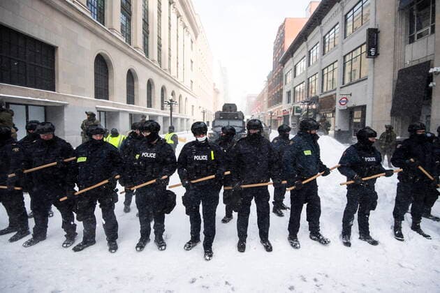 February 19, 2022, Ottawa, ON, Canada: Police clutch batons as they form a line to block Sparks Street, restricting access to the streets near Parliament Hill, they take action to put an end to a protest, which started in opposition to mandatory COVID-19 vaccine mandates and grew into a broader anti-government demonstration and occupation, on its 23rd day, in Ottawa, Saturday, Feb. 19, 2022. Ottawa Canada  - ZUMAc35_ 20220219_zaf_c35_156 Copyright: xJustinxTangx