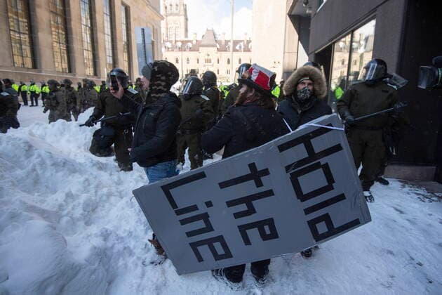 News Bilder des Tages February 19, 2022, Ottawa, ON, Canada: A protester wears a giant placard with a call to Hold the Line, as police work to clear the streets in front of Parliament Hill to put an end to a protest, which started in opposition to mandatory COVID-19 vaccine mandates and grew into a broader anti-government demonstration and occupation, on its 23rd day, in Ottawa, Saturday, Feb. 19, 2022. Ottawa Canada  - ZUMAc35_ 20220219_zaf_c35_174 Copyright: xJustinxTangx