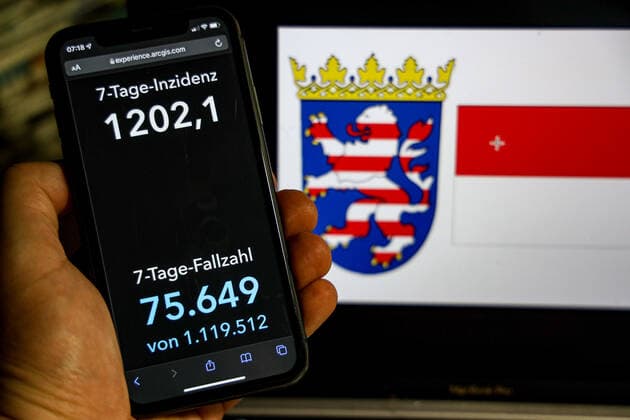 Coronavirus in Germany Covid 19 Dashboard of the Robert Koch Institute DEU, Germany, Hesse 20 02 2022 The 7-day incidence for the state Cases last 7 days 100 000 p.e. is displayed on an iPhone, with the state coat of arms in the background.