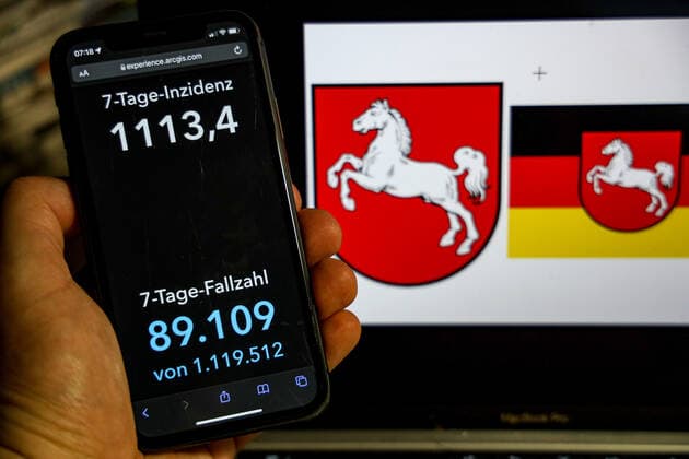 Coronavirus in Germany Covid 19 Dashboard of the Robert Koch Institute DEU, Germany, Lower Saxony 20 02 2022 The 7-day incidence for the state Cases last 7 days 100 000 p.e. is displayed on an iPhone, with the state coat of arms in the background.