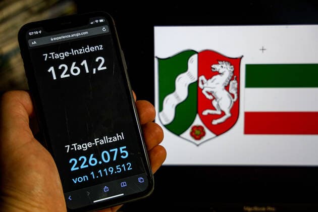 Coronavirus in Germany Covid 19 Dashboard of the Robert Koch Institute DEU, Germany, North Rhine Westphalia 20 02 2022 The 7-day incidence for the state Cases last 7 days 100 000 p.e. is displayed on an iPhone, with the state coat of arms in the background.