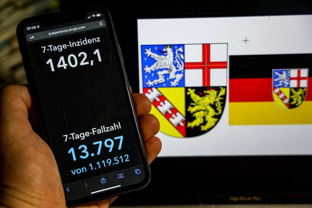 Coronavirus in Germany Covid 19 Dashboard of the Robert Koch Institute DEU, Germany, Saarland 20 02 2022 The 7-day incidence for the state Cases last 7 days 100 000 PE is displayed on an iPhone, with the state coat of arms in the background.