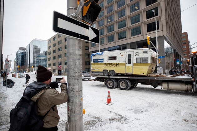 February 20, 2022, OTTAWA, ON, CANADA: A man takes pictures as a camper gets hauled away in Ottawa on Sunday, Feb. 20, 2022, after police worked to clear a trucker protest that was aimed at COVID-19 measures that grew into a broader anti-government protest. OTTAWA CANADA  - ZUMAc35_ 20220220_zaf_c35_052 Copyright: xColexBurstonx