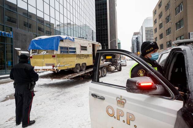 February 20, 2022, OTTAWA, ON, CANADA: OPP officers look on as camper gets hauled away in Ottawa on Sunday, Feb. 20, 2022, after police worked to clear a trucker protest that was aimed at COVID-19 measures that grew into a broader anti-government protest. OTTAWA CANADA  - ZUMAc35_ 20220220_zaf_c35_053 Copyright: xColexBurstonx