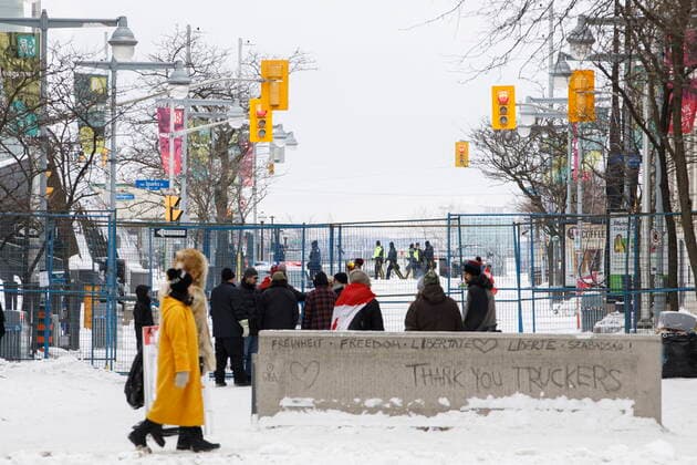 February 20, 2022, OTTAWA, ON, CANADA: People stand outside of a fenced off portion of downtown Ottawa on Sunday, Feb. 20, 2022, after police worked to clear a trucker protest that was aimed at COVID-19 measures before growing into a broader anti-government protest. OTTAWA CANADA  - ZUMAc35_ 20220220_zaf_c35_059 Copyright: xColexBurstonx