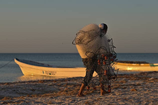 Daily Life In Celestun During The Covid-19 Pandemic A local fisherman carries nets as preparing his fishing boat on the beach of Celestun. On Tuesday, February 22, 2022, in Celestun, Yucatan, Mexico. Celestun Mexico  Copyright: xArturxWidakx originalFilename: widak-dailylif220222_np2pt.jpg