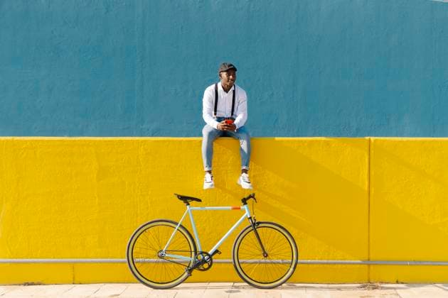 Man with smart phone and bicycle sitting on yellow wall model released, JCZF00971