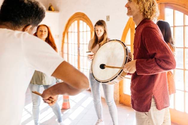 Mature man playing drum by friends in music classroom model released property released, JRFF05282