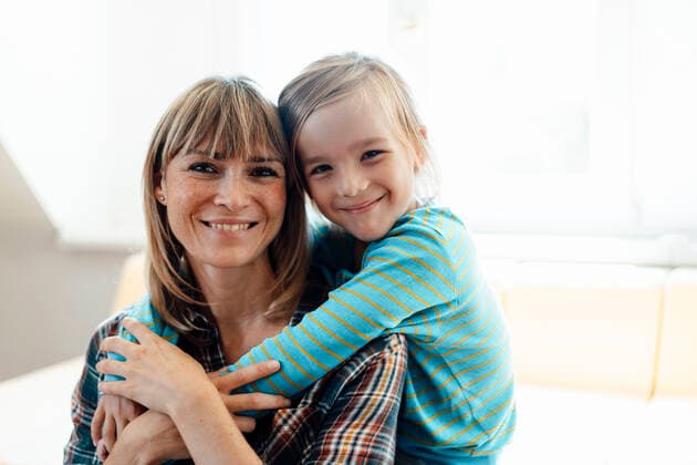 Smiling mother and son together in living room model released property released, JOSEF07083