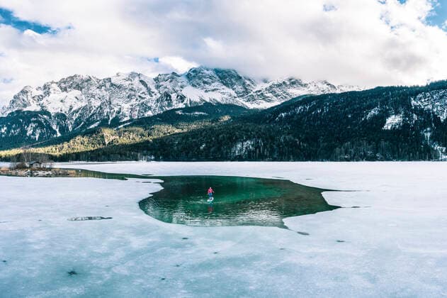 IMAGO Creative, Winter, Winterspaß, Eishockey Germany, Bavaria, Aerial view of lone man paddleboarding between ice floes in Eibsee lake model released, Grainau Bayern Deutschland Eibsee WFF00689