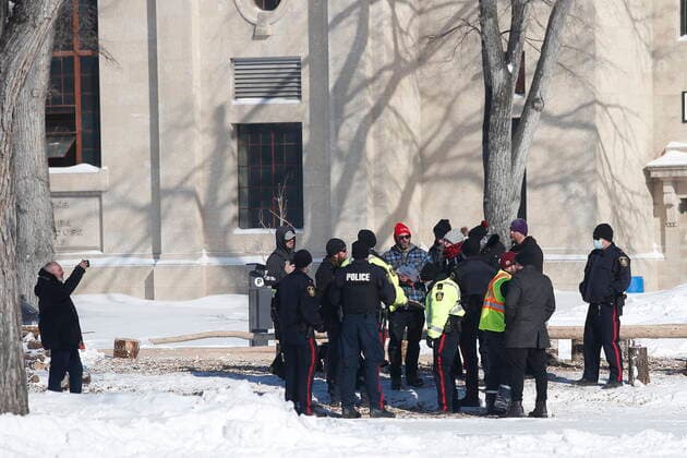 February 23, 2022, WINNIPEG, MANITOBA, CANADA: Police talk to organizers of a COVID-19 mandate protest as they prepare to head home Wednesday, February 23, 2022. The group received a notice from the Winnipeg Police that they have a deadline of 5pm Wednesday to move off the street and unblock Memorial Blvd. The group plans to depart peacefully and set up a camp in a nearby park. WINNIPEG CANADA  - ZUMAc35_ 20220223_zaf_c35_080 Copyright: xJohnxWoodsx