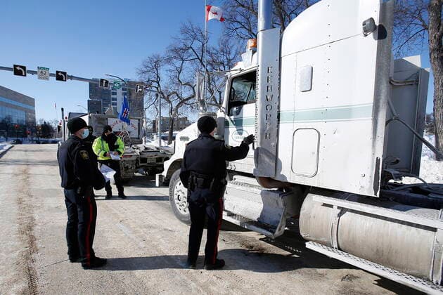 February 23, 2022, WINNIPEG, MANITOBA, CANADA: Winnipeg police talk to the lead driver in a convoy of COVID-19 mandate protest trucks as they head home Wednesday, February 23, 2022. The group received a notice from the Winnipeg Police that they have a deadline of 5pm Wednesday to move off the street and unblock Memorial Blvd. The group plans to depart peacefully and set up a camp in a nearby park. WINNIPEG CANADA  - ZUMAc35_ 20220223_zaf_c35_083 Copyright: xJohnxWoodsx