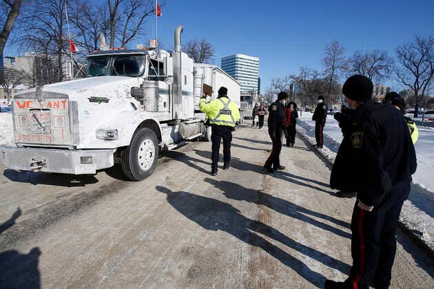 February 23, 2022, WINNIPEG, MANITOBA, CANADA: Winnipeg police talk to the lead driver in a convoy of COVID-19 mandate protest trucks as they head home Wednesday, February 23, 2022. The group received a notice from the Winnipeg Police that they have a deadline of 5pm Wednesday to move off the street and unblock Memorial Blvd. The group plans to depart peacefully and set up a camp in a nearby park. WINNIPEG CANADA  - ZUMAc35_ 20220223_zaf_c35_085 Copyright: xJohnxWoodsx